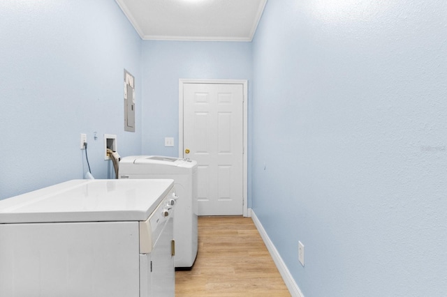 clothes washing area featuring separate washer and dryer, crown molding, and light hardwood / wood-style floors