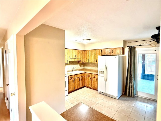 kitchen with stove, white refrigerator with ice dispenser, sink, ceiling fan, and light tile patterned floors