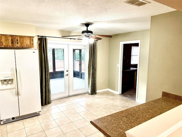 interior space with french doors, a textured ceiling, light tile patterned floors, and ceiling fan