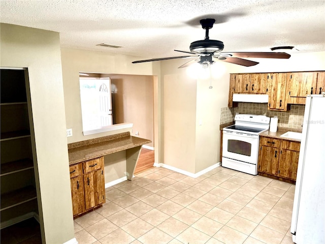 kitchen featuring ceiling fan, backsplash, a textured ceiling, white appliances, and light tile patterned flooring