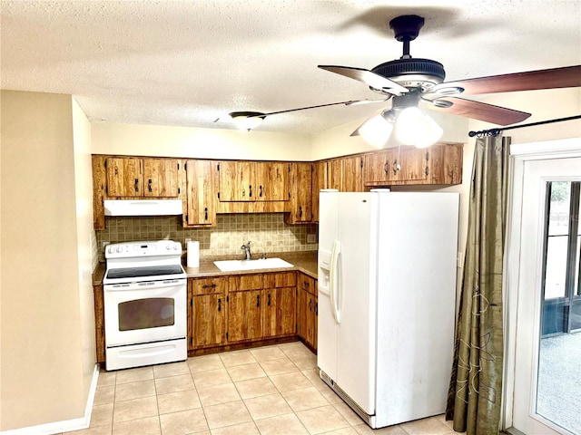 kitchen featuring tasteful backsplash, white appliances, a textured ceiling, sink, and light tile patterned floors