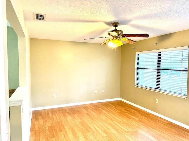 empty room featuring wood-type flooring, a textured ceiling, and ceiling fan