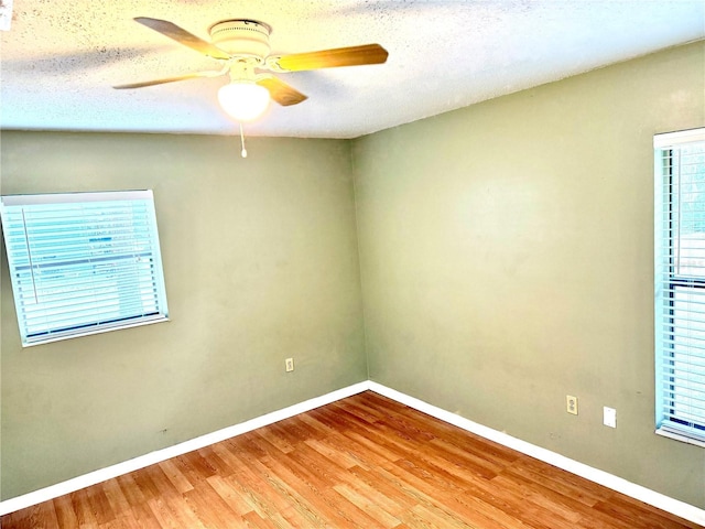 empty room with ceiling fan, hardwood / wood-style floors, and a textured ceiling