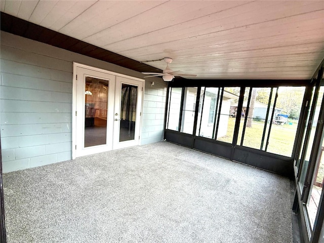 unfurnished sunroom featuring ceiling fan and french doors