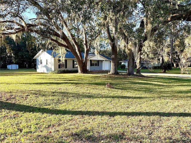 view of front of house with a shed and a front yard