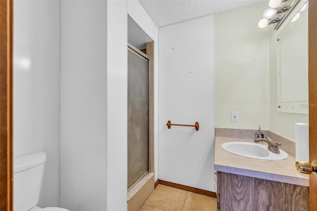 bathroom featuring tile patterned flooring, a textured ceiling, toilet, vanity, and a shower with shower door