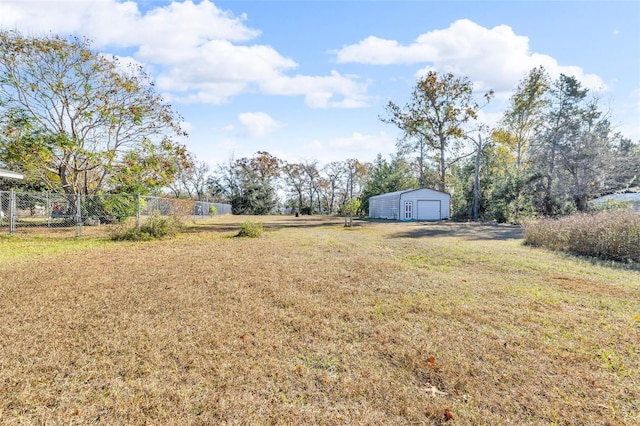 view of yard featuring a garage and an outbuilding