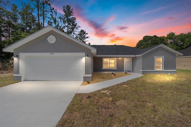 single story home with a garage and a lawn