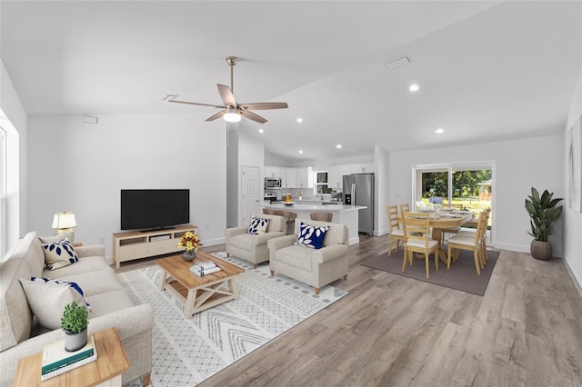 living room featuring light hardwood / wood-style floors, ceiling fan, and lofted ceiling