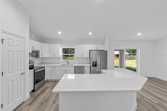 kitchen with a center island, white cabinetry, sink, and appliances with stainless steel finishes