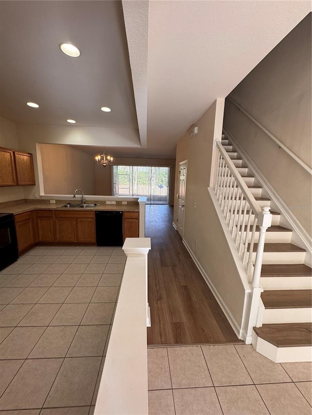 kitchen featuring a chandelier, sink, black dishwasher, and light tile patterned flooring