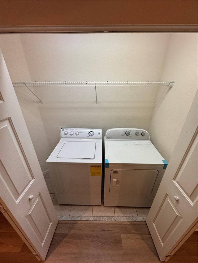 laundry room featuring washer and dryer and light hardwood / wood-style flooring