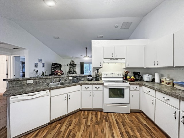 kitchen featuring white appliances, white cabinets, sink, vaulted ceiling, and kitchen peninsula