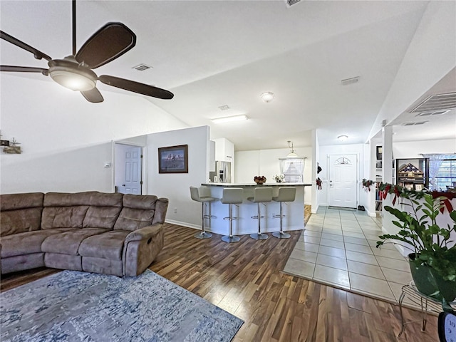 living room featuring ceiling fan, hardwood / wood-style floors, and lofted ceiling