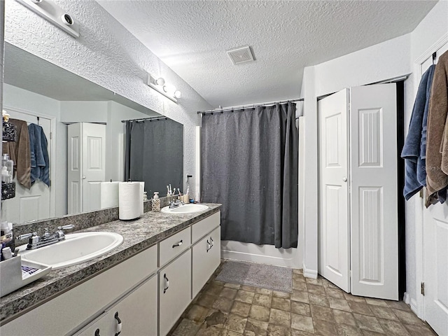 bathroom featuring vanity, shower / bath combination with curtain, and a textured ceiling