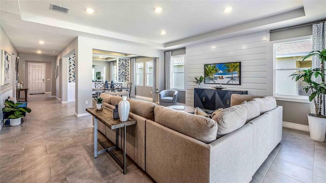 living room with plenty of natural light and a raised ceiling