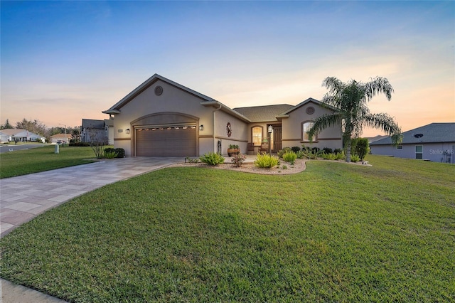 ranch-style home featuring a lawn and a garage