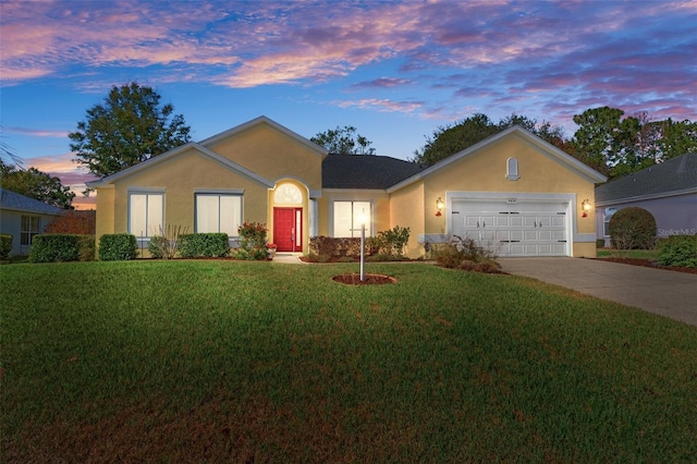 ranch-style home featuring a lawn and a garage