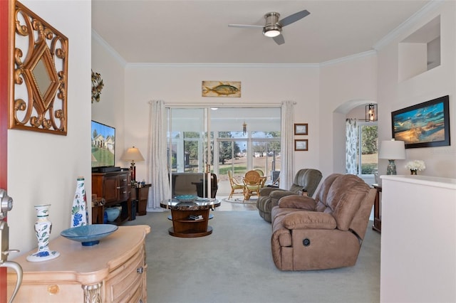 living room with carpet floors, crown molding, ceiling fan, and a healthy amount of sunlight