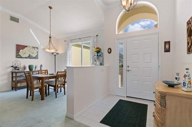 entryway featuring light carpet, ornamental molding, vaulted ceiling, and a healthy amount of sunlight