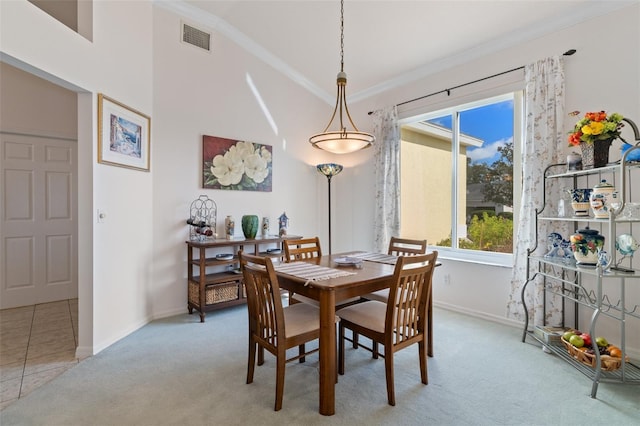 carpeted dining area featuring vaulted ceiling and ornamental molding