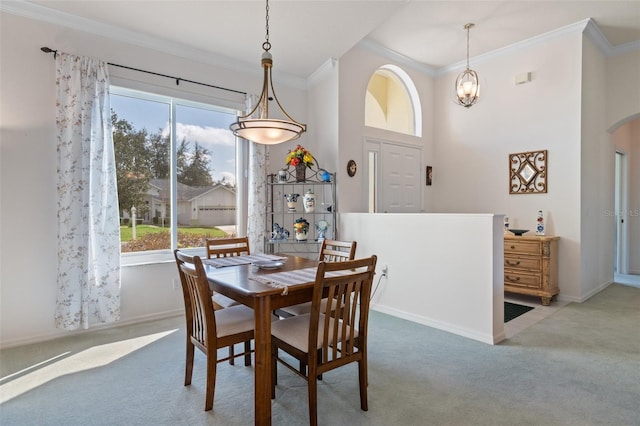 dining space featuring light carpet, ornamental molding, a healthy amount of sunlight, and an inviting chandelier