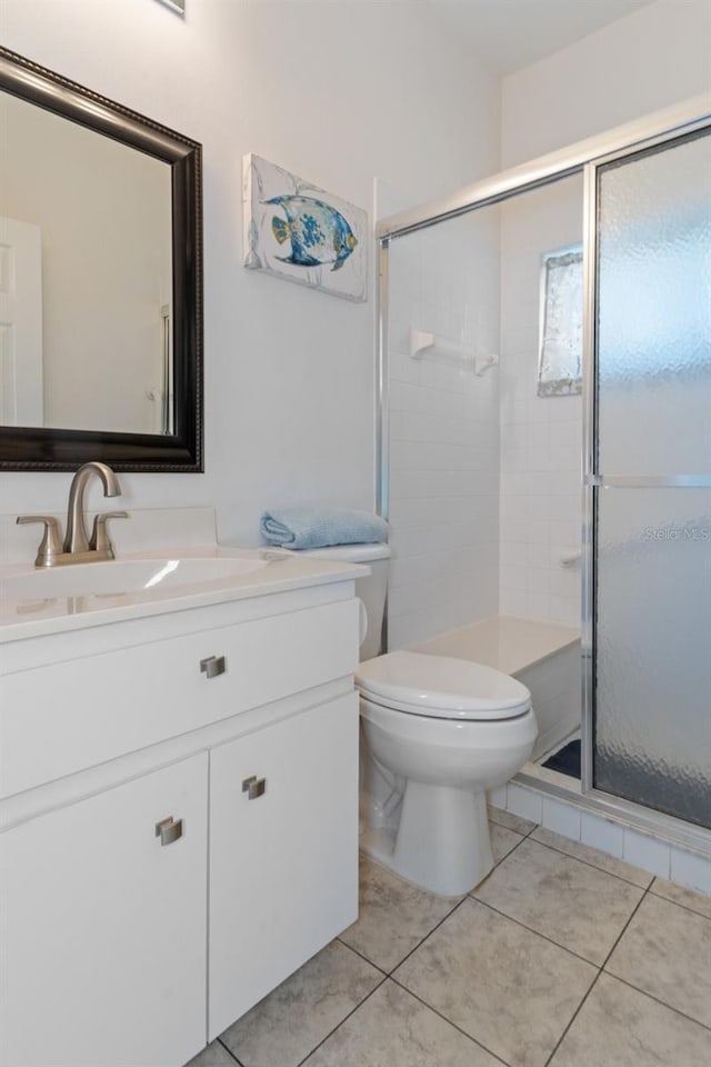 bathroom featuring tile patterned floors, toilet, vanity, and walk in shower