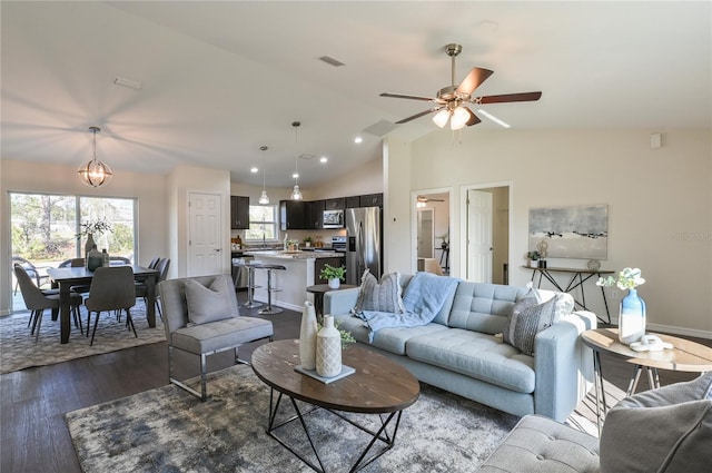 living room featuring dark hardwood / wood-style floors, lofted ceiling, and ceiling fan with notable chandelier