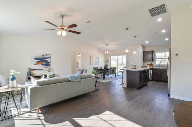 living room featuring a wealth of natural light, vaulted ceiling, ceiling fan, and sink