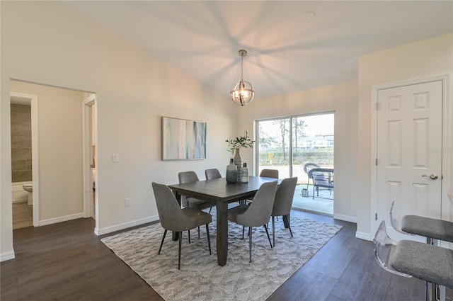 dining room featuring lofted ceiling, dark wood-type flooring, and a chandelier