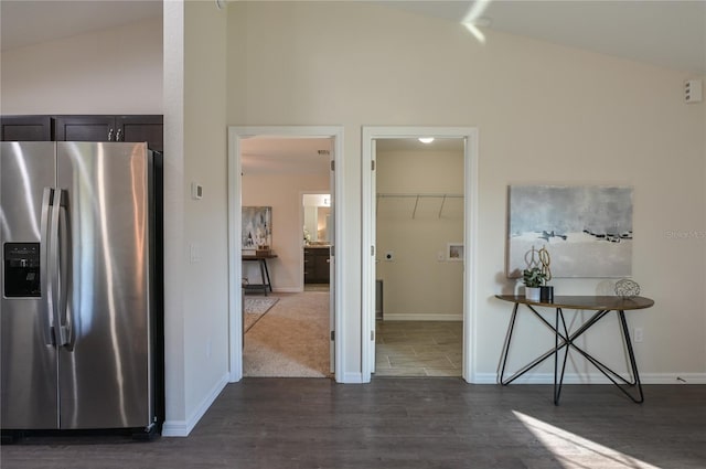 interior space with stainless steel fridge, dark hardwood / wood-style flooring, and lofted ceiling