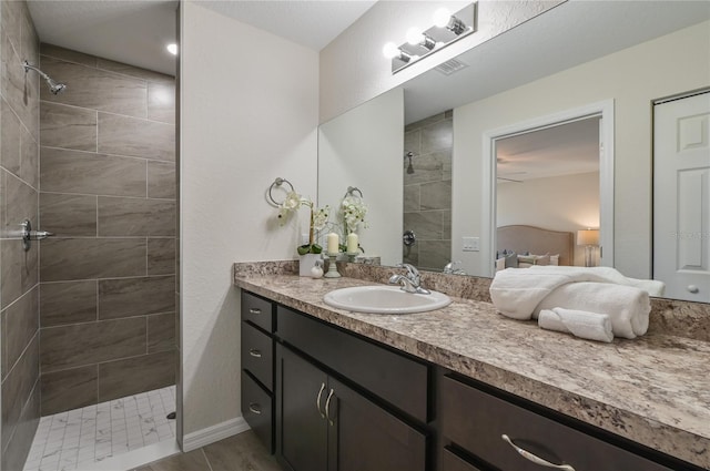 bathroom with vanity, wood-type flooring, and tiled shower