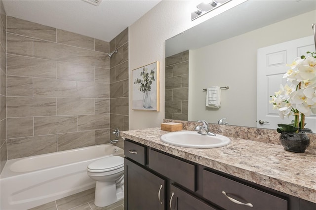 full bathroom featuring tiled shower / bath, vanity, and toilet