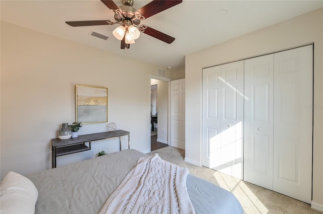 carpeted bedroom featuring ceiling fan and a closet