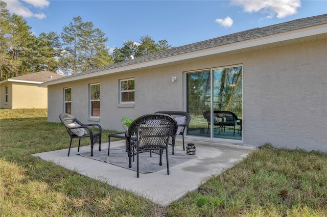 rear view of property with a lawn and a patio