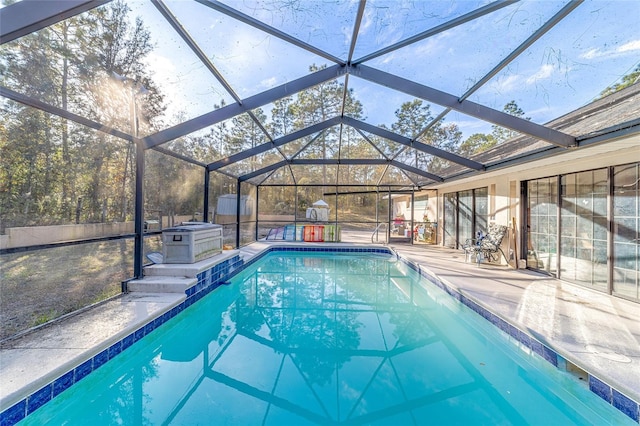 view of swimming pool featuring a lanai, a patio area, and a storage unit