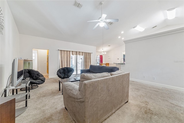 living room with ceiling fan with notable chandelier, light colored carpet, and vaulted ceiling