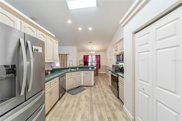 kitchen with lofted ceiling, sink, decorative light fixtures, appliances with stainless steel finishes, and a notable chandelier