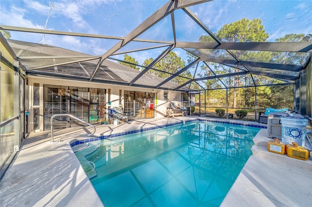 view of pool with glass enclosure and a patio area