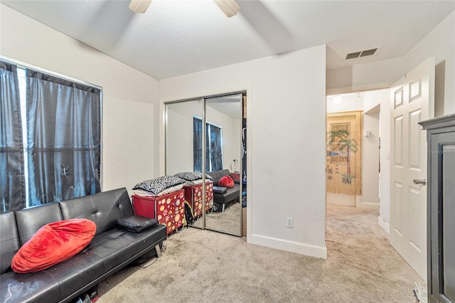 living area featuring ceiling fan and light colored carpet