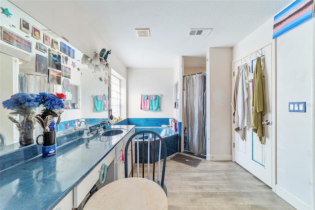 bathroom featuring vanity, hardwood / wood-style floors, and a textured ceiling