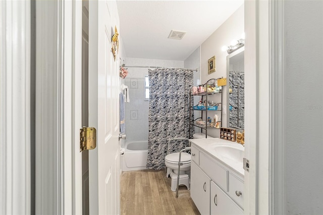 full bathroom featuring hardwood / wood-style floors, vanity, toilet, and shower / tub combo with curtain