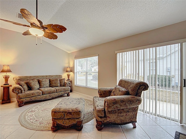 tiled living room with ceiling fan, a textured ceiling, a wealth of natural light, and vaulted ceiling