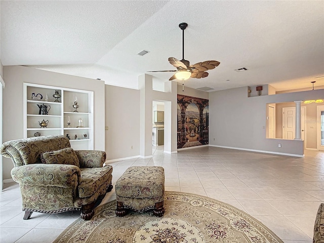 living room featuring vaulted ceiling, ceiling fan, built in features, a textured ceiling, and light tile patterned flooring