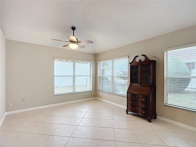 tiled empty room featuring a textured ceiling and ceiling fan