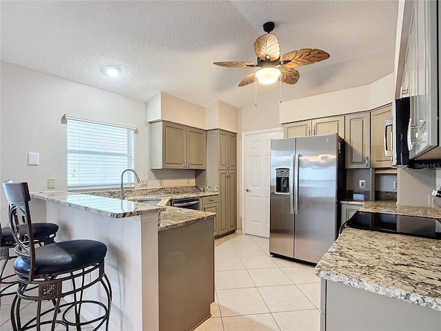 kitchen featuring kitchen peninsula, a textured ceiling, stainless steel appliances, ceiling fan, and sink