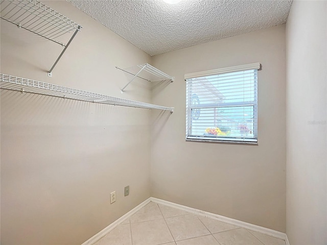 interior space featuring light tile patterned floors and a textured ceiling