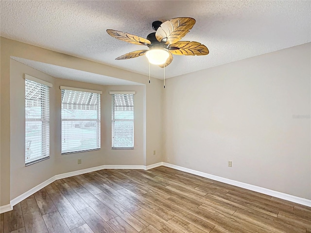 unfurnished room featuring ceiling fan, wood-type flooring, and a textured ceiling