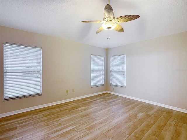 unfurnished room with ceiling fan, light hardwood / wood-style floors, and a textured ceiling