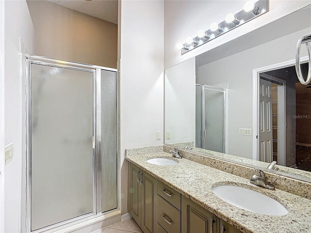 bathroom with tile patterned flooring, vanity, and a shower with door